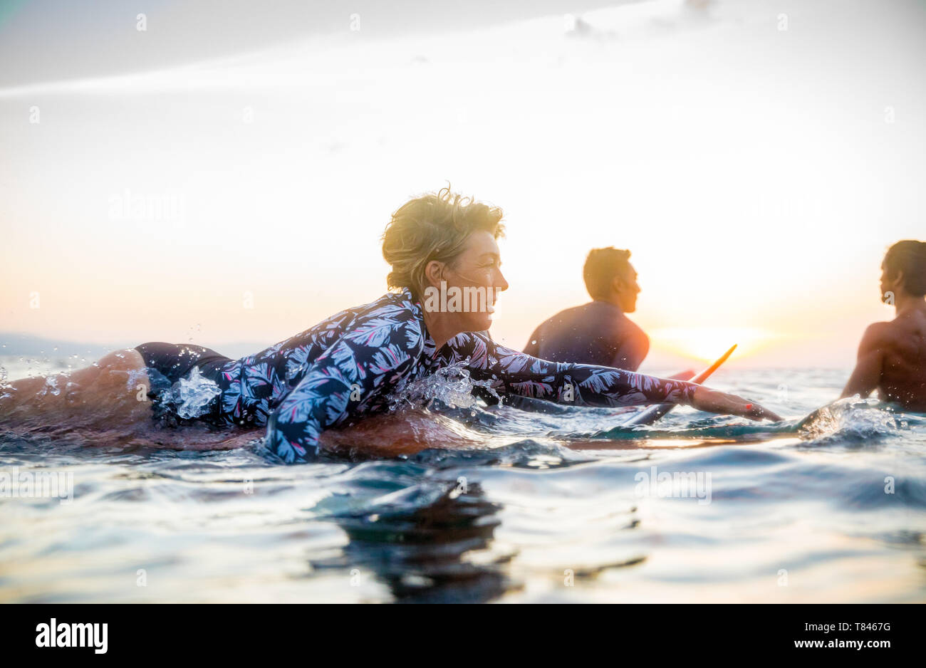 Surfer gleiten im Meer bei Sonnenuntergang, Pagudpud, Ilocos Norte, Philippinen Stockfoto