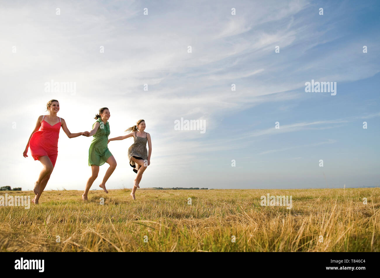 Freundinnen Überspringen auf Feld, Eastbourne, East Sussex, Großbritannien Stockfoto