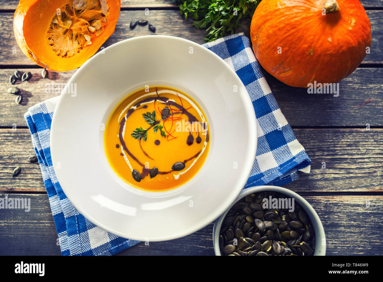 Kürbis Cremesuppe mit Samen und Petersilie auf dem Küchentisch Stockfoto