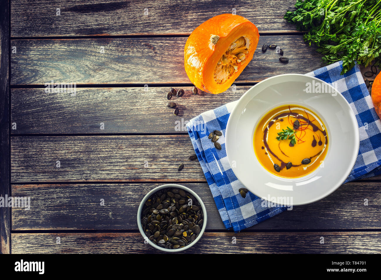 Kürbis Cremesuppe mit Samen und Petersilie auf Küche Tisch- Sicht Stockfoto