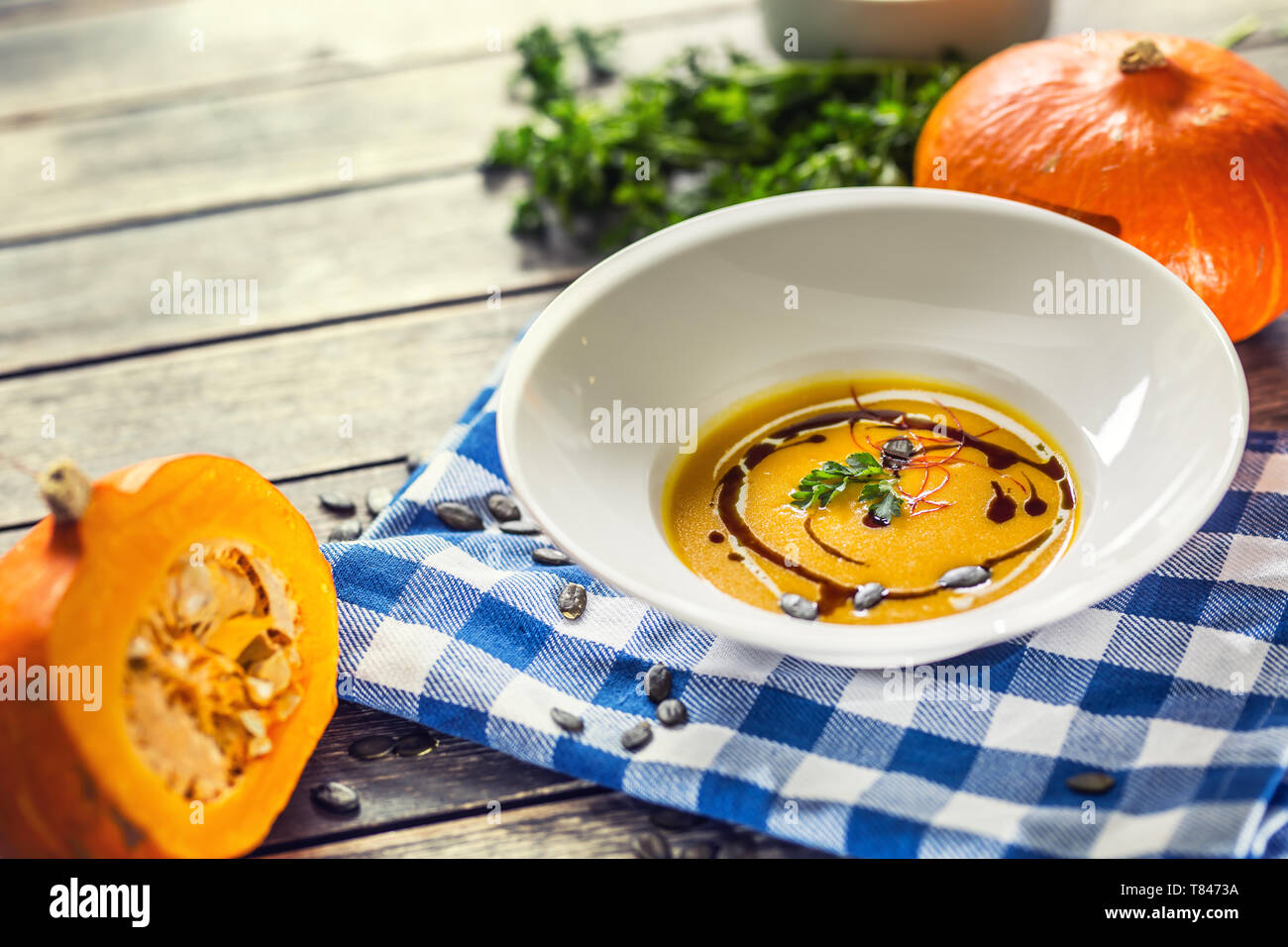 Kürbis Cremesuppe mit Samen und Petersilie auf dem Küchentisch Stockfoto