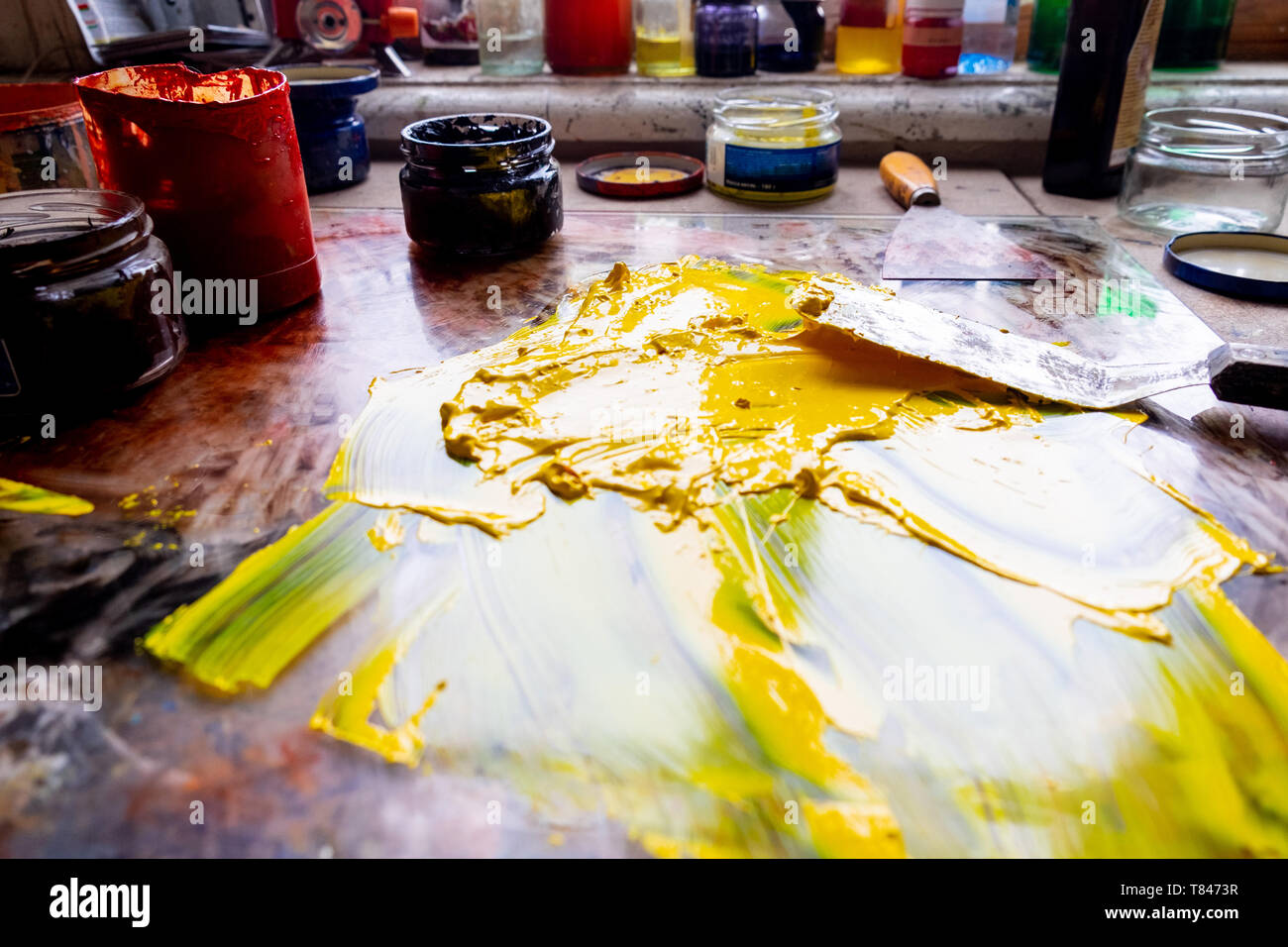 Verschüttete gelbe Farbe auf Tabelle Stockfoto