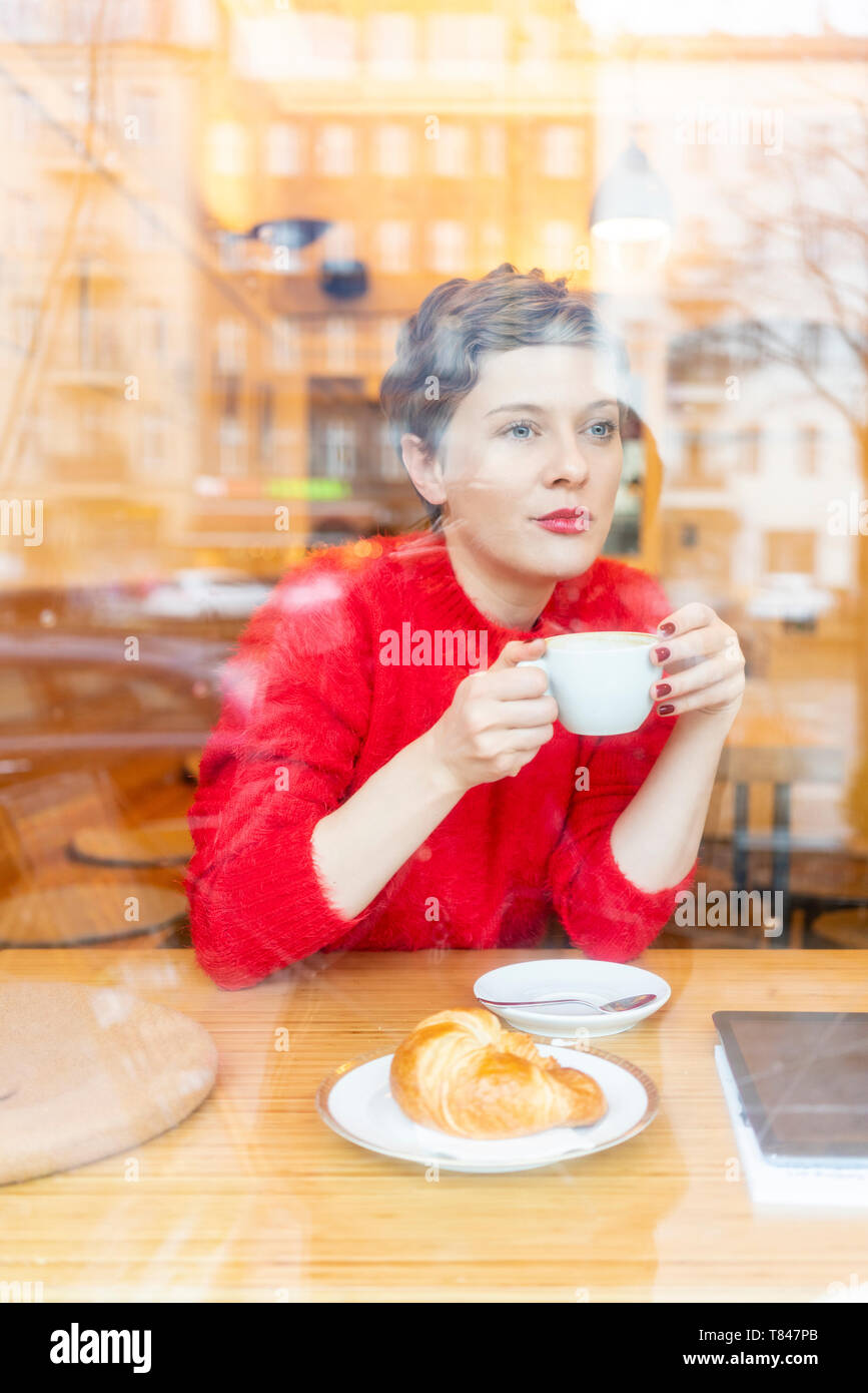 Mitte der erwachsenen Frau im Cafe Kaffee trinken heraus suchen, Fenster anzeigen Stockfoto
