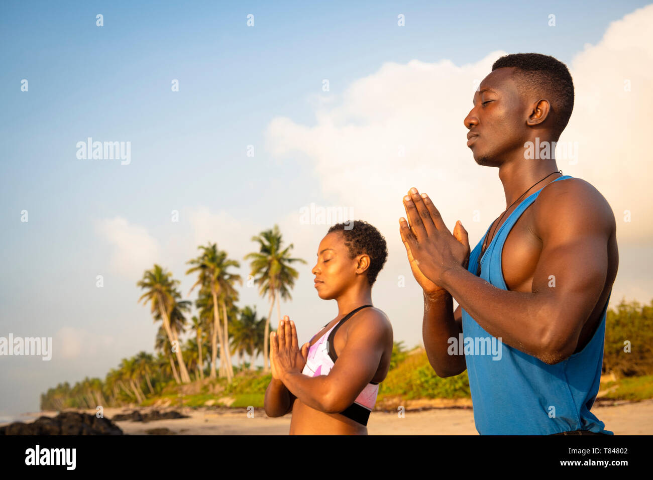 Paar Üben Yoga am Strand. Stockfoto