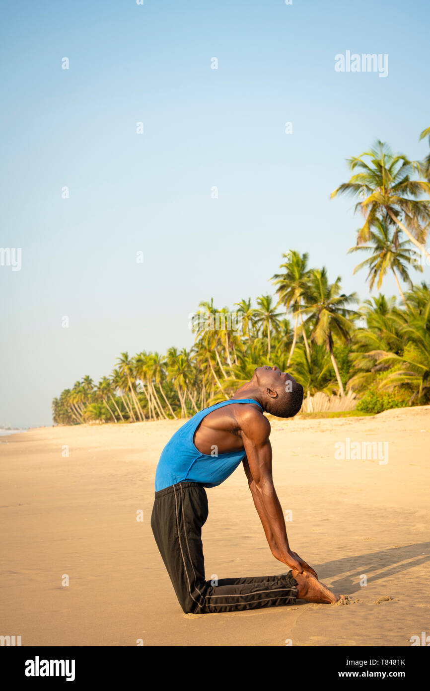 Man Yoga am Strand. Stockfoto
