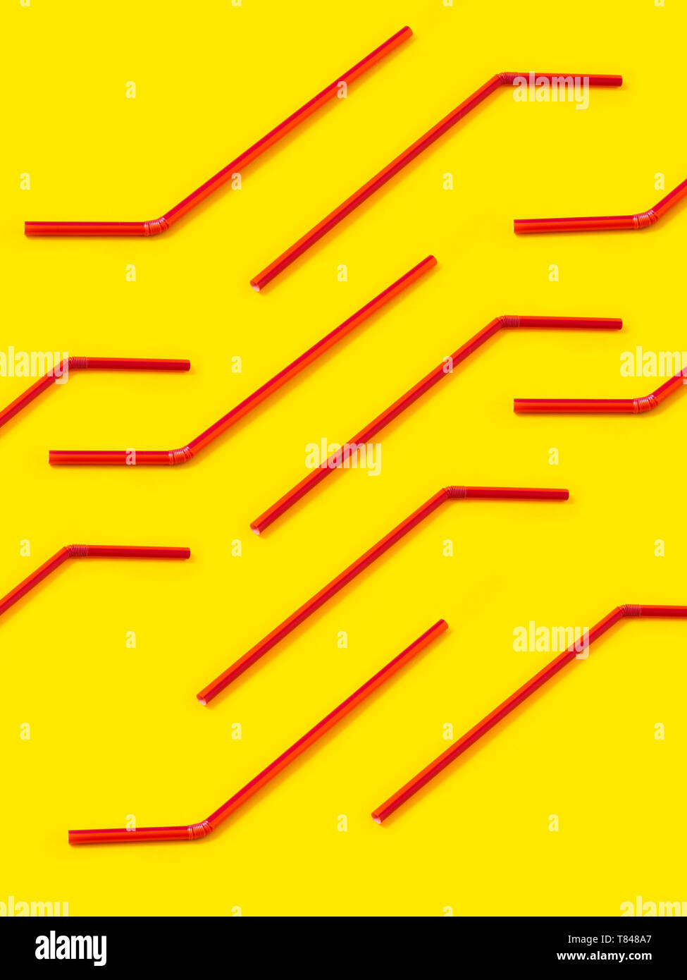 Red Strohhalme festgelegten diagonal auf gelbem Hintergrund Stockfoto