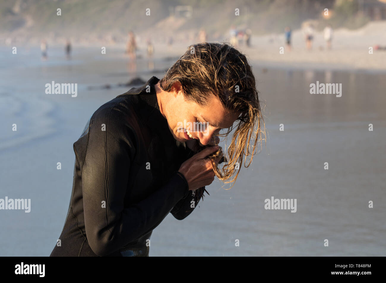 Weibliche Surfer mit Händen in nassem Haar an der Beach, Cape Town, Western Cape, Südafrika Stockfoto