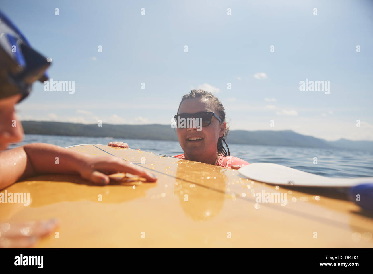 Paar Paddle Boarding in See Stockfoto