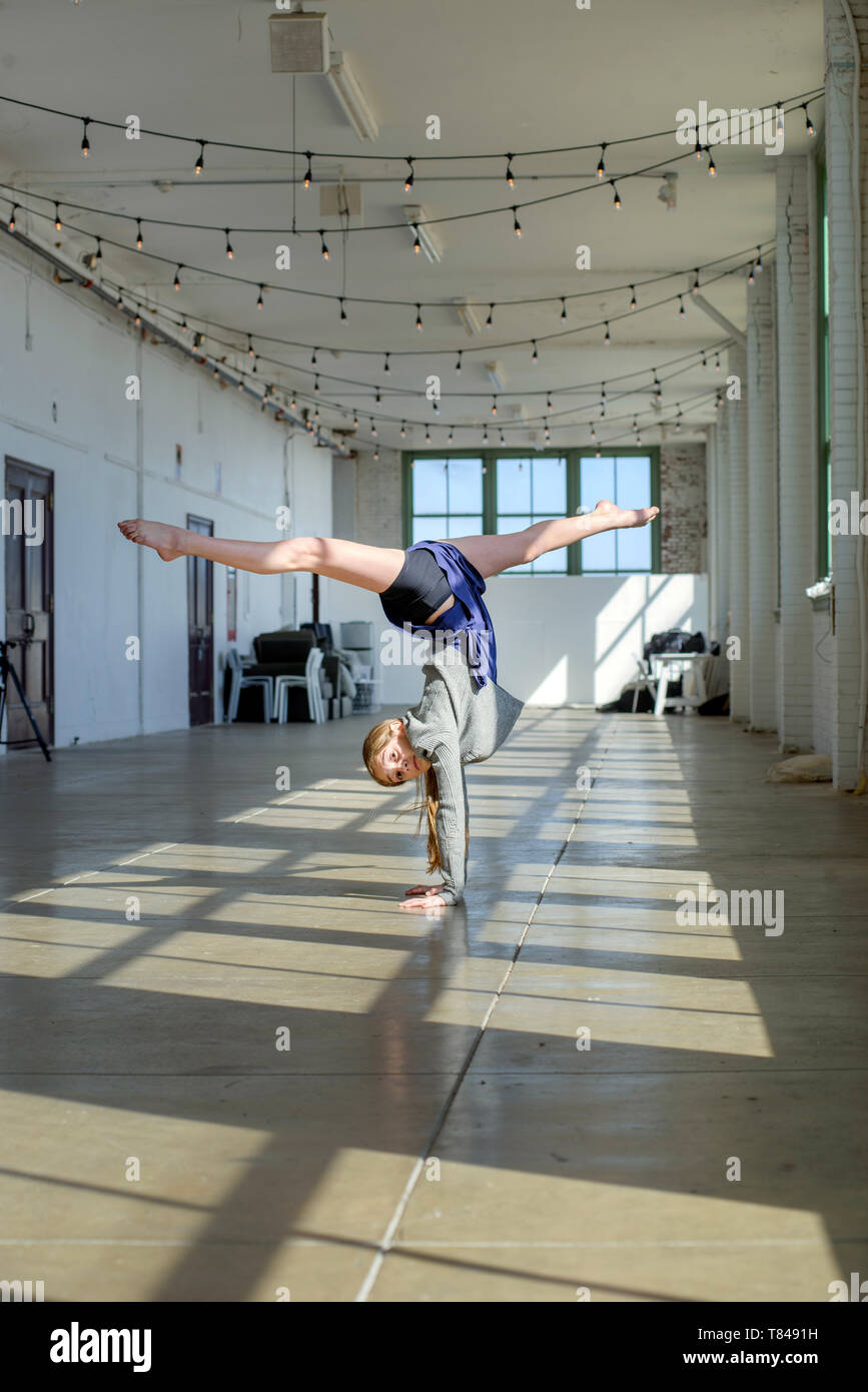 Junges Mädchen tun, Handstand und Splits in Dance Studio Stockfoto