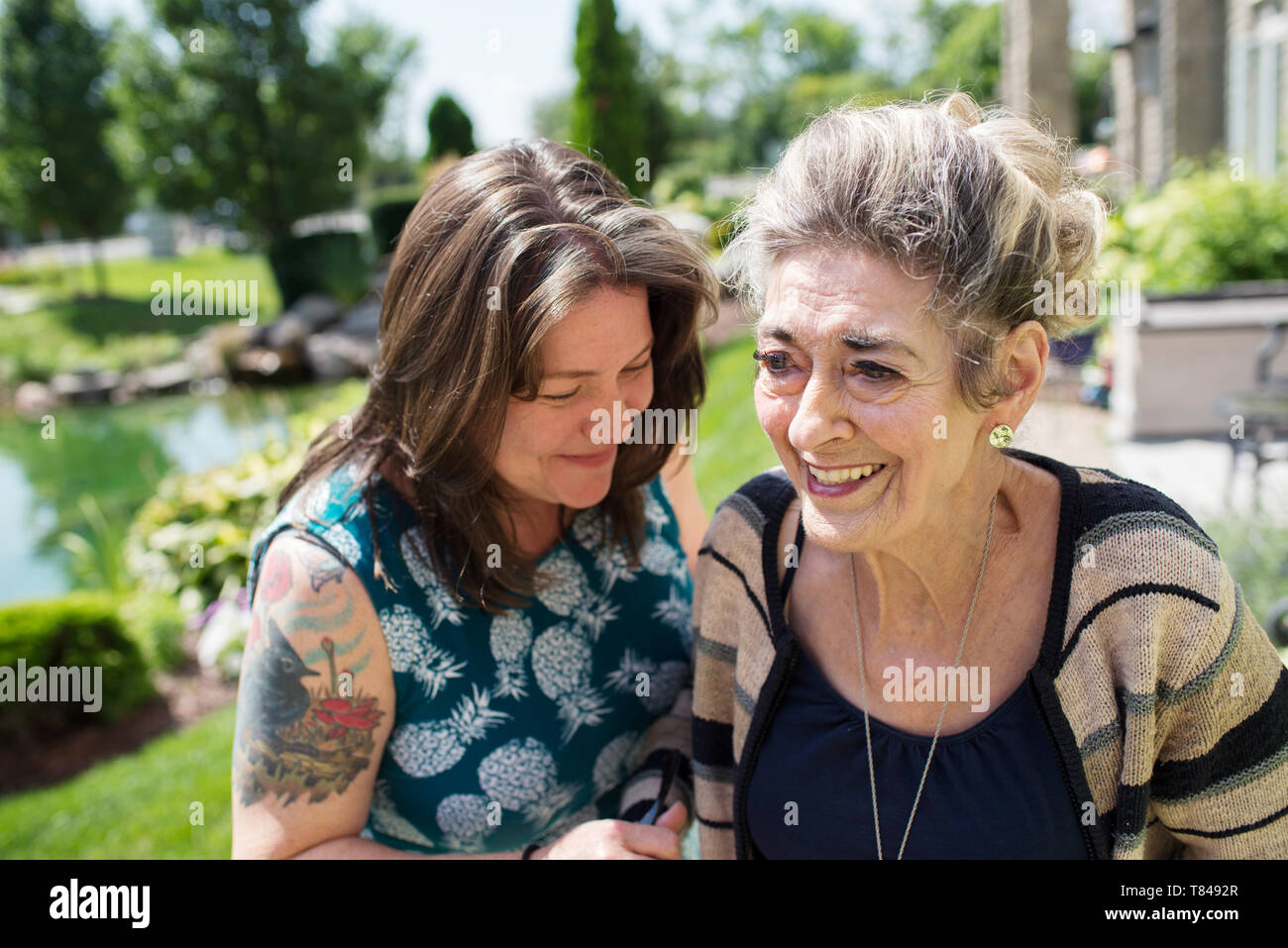 Frau lachend mit ihrer Mutter im Garten Stockfoto