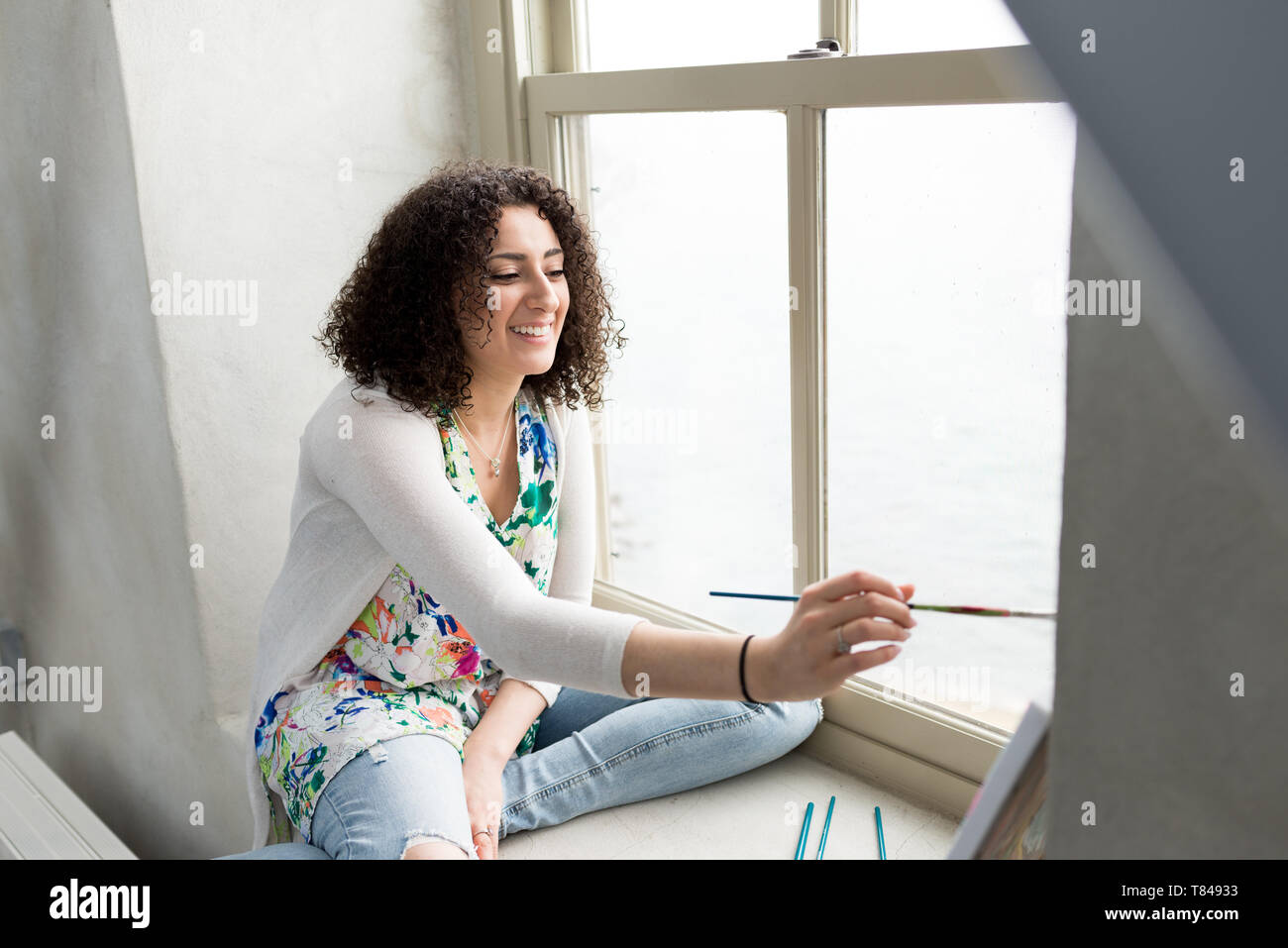 Junge weibliche Maler Malerei Leinwand auf Studio Fensterbänke Stockfoto