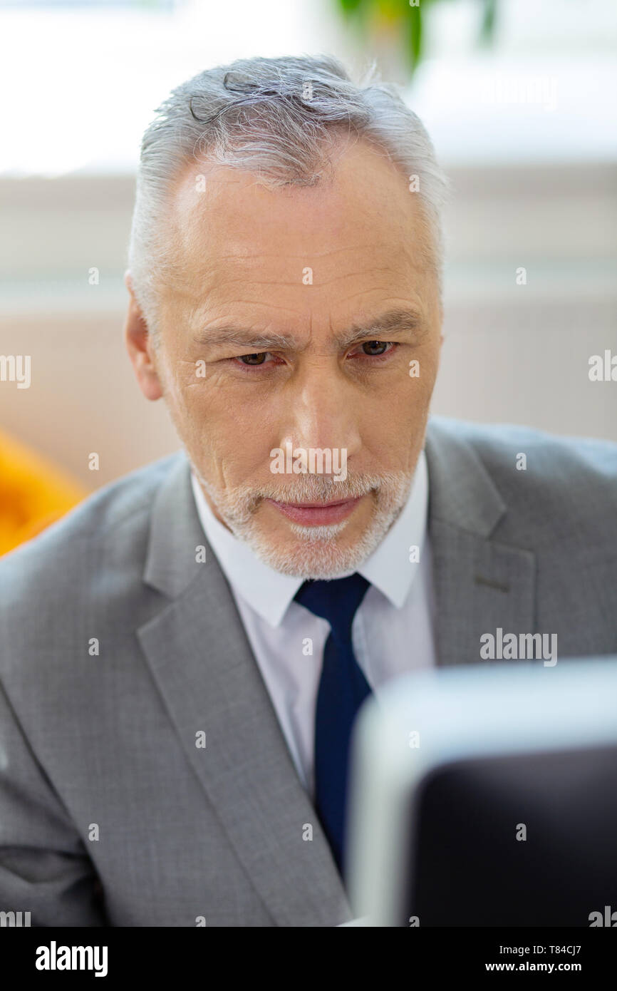 Grau - behaarte arbeitenden Menschen, seinem Arbeitsplatz Stockfoto