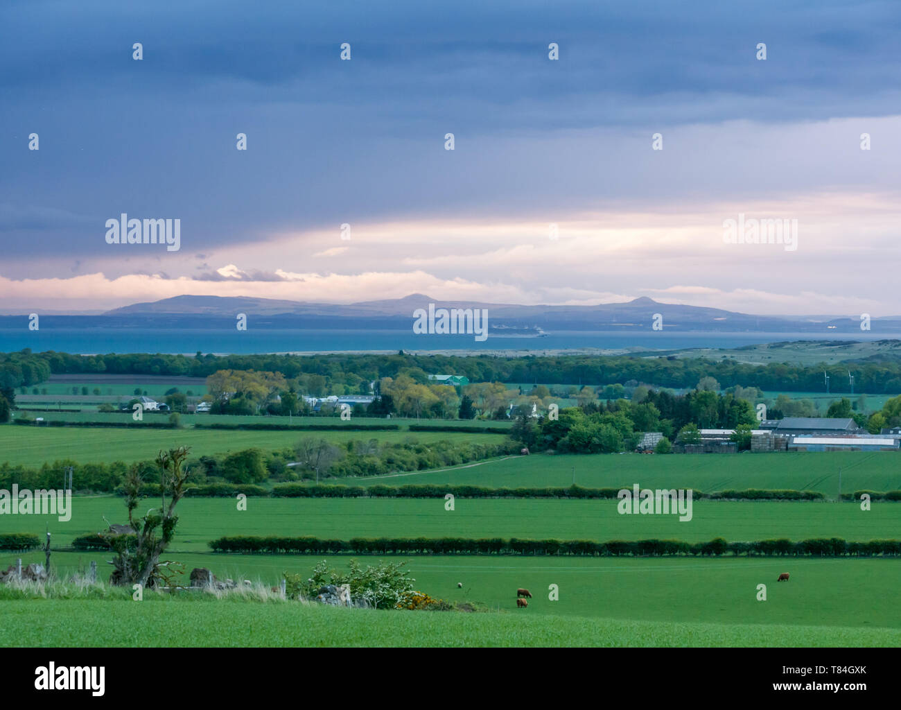 East Lothian, Schottland, Großbritannien. 10. Mai 2019. UK Wetter: Regen Wolken sammeln und der Himmel verdunkelt von Westen über die Grafschaft bei Sonnenuntergang mit Blick auf den Firth-of-Forth und die Lomond Hills in der Fife Stockfoto