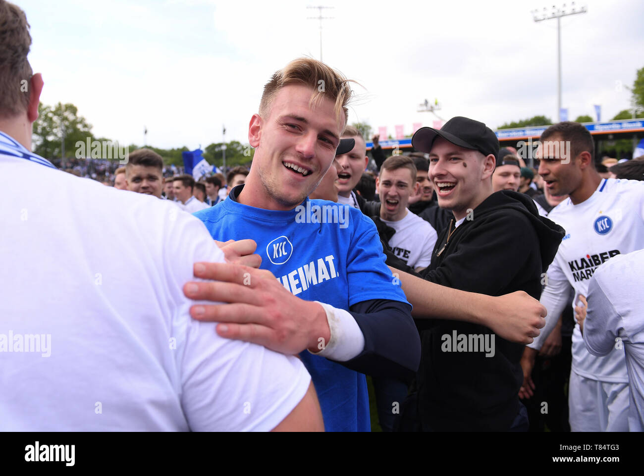 Münster, Deutschland. 11. Mai, 2019. Aufstieg: Der KSC gewinnt bei Preussen Muenster und steigt in die Zweite Bundesliga: KSC Fans feiern nach dem Spiel mit Alexander Groiss (KSC). GES/Fußball/3. Liga: Preussen Muenster - Karlsruher SC, 11.05.2019 Fußball: 3. Liga: Preussen Muenster vs Karlsruher SC, Muenster, Mai 11, 2019 | Verwendung der weltweiten Kredit: dpa/Alamy leben Nachrichten Stockfoto