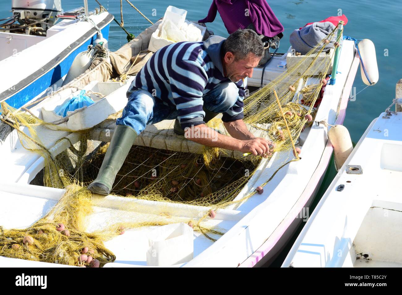 Albanische Fischer auf einem kleinen Fischerboot Instandsetzung Fischernetz Saranda Albanien Stockfoto