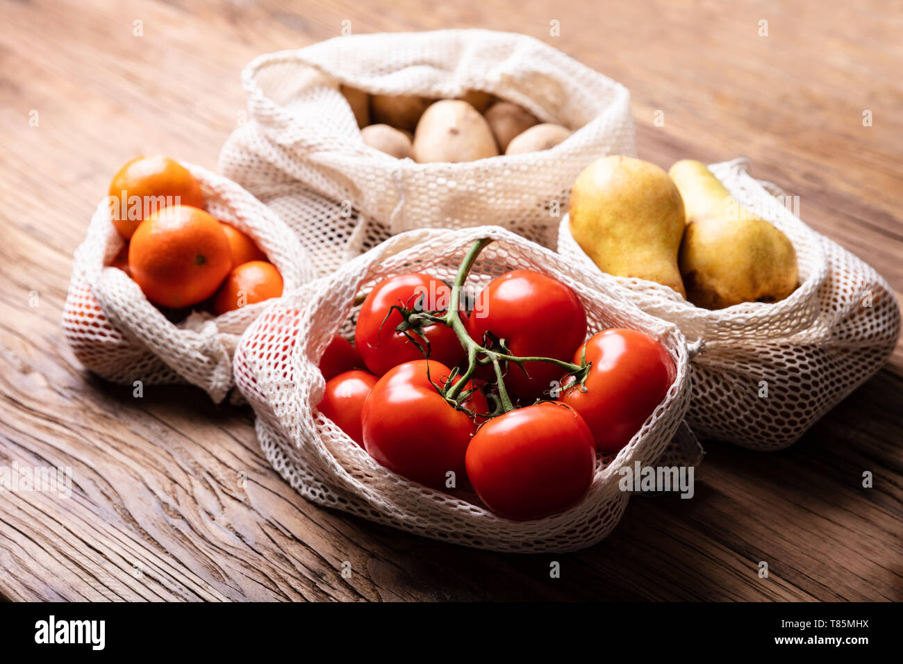 Eine Ansicht von Gemüse und Früchten in der Tasche über Holz- Schreibtisch Stockfoto