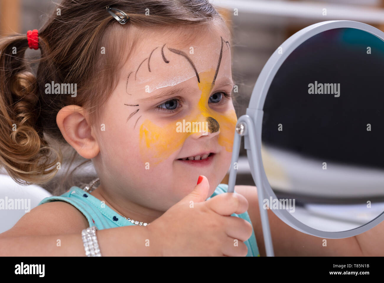Malerei das Gesicht eines kleinen Mädchen mit Farbe, Pinsel Stockfoto