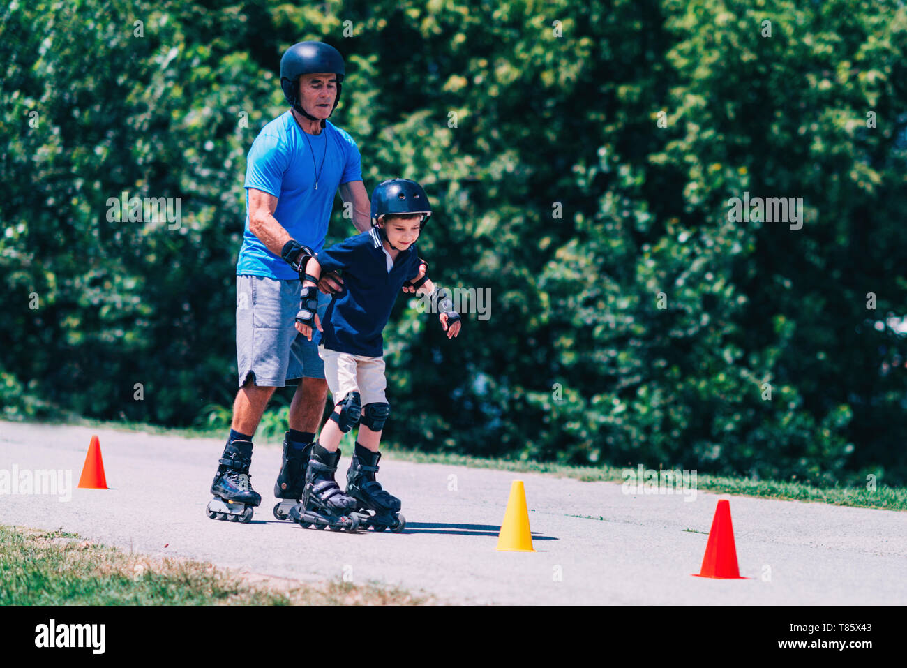 Großvater lehre Enkel zu Roller Skate Stockfoto