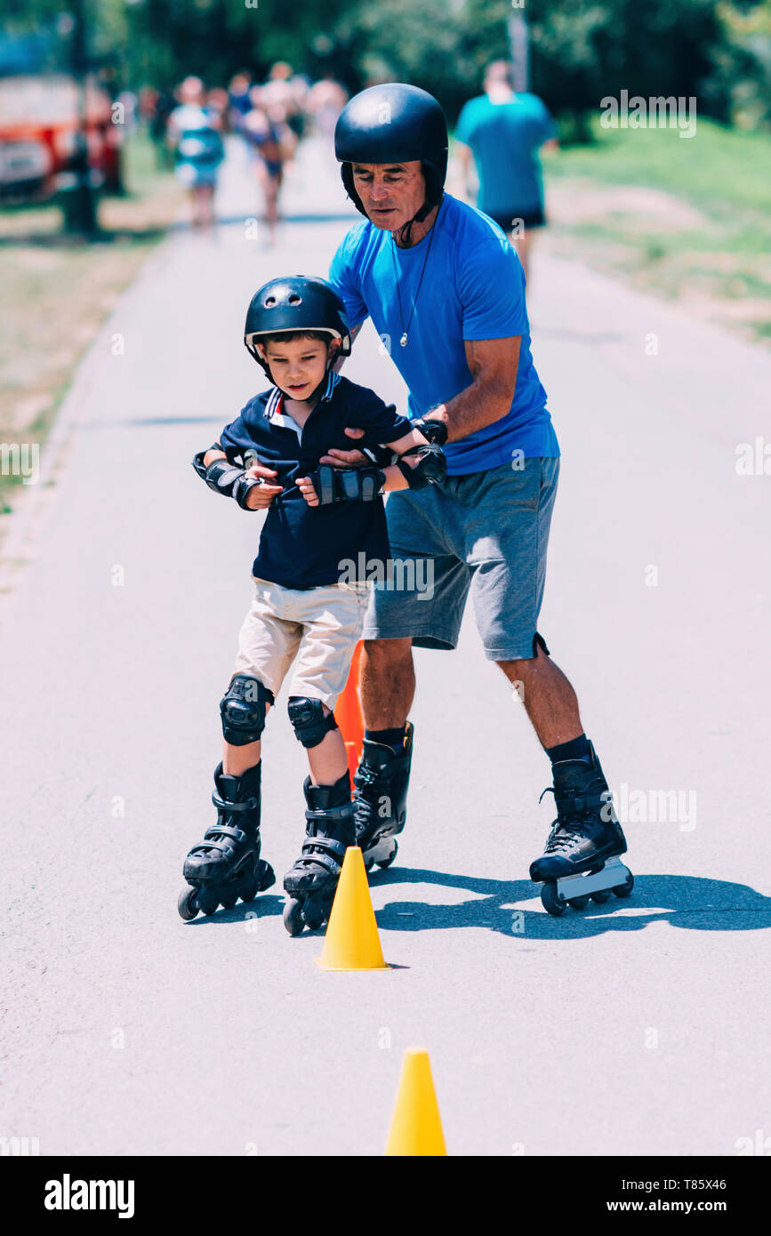 Großvater lehre Enkel zu Roller Skate Stockfoto