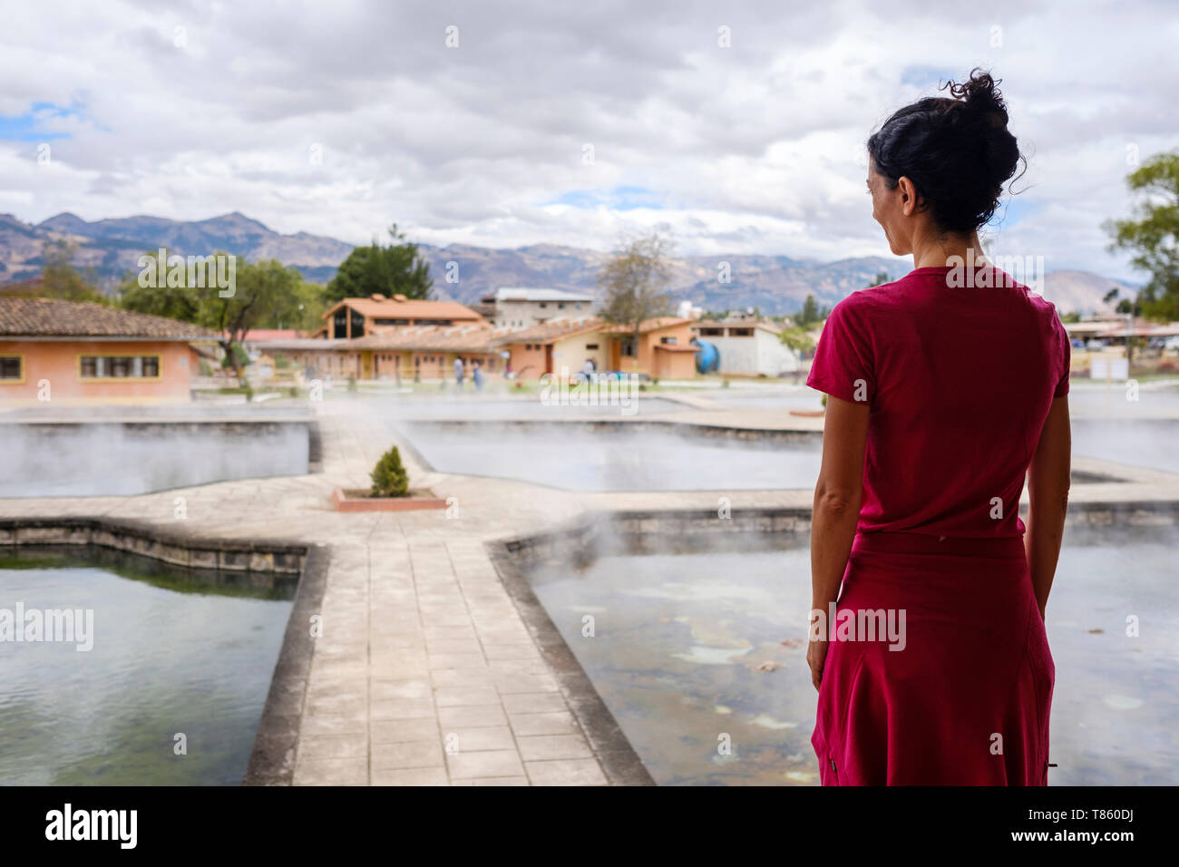 Weibliche Besucher betrachten die Dampf aus die Thermalbäder draußen in Los Baños del Inca in der Nähe von Cajamarca in Peru Stockfoto