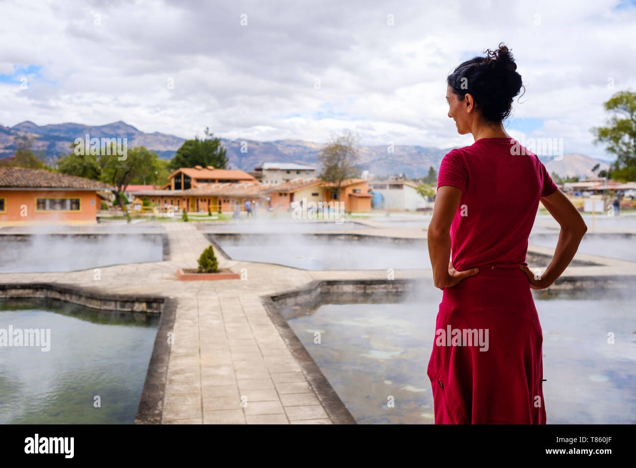 Weibliche Besucher betrachten die Dampf aus die Thermalbäder draußen in Los Baños del Inca in der Nähe von Cajamarca in Peru Stockfoto