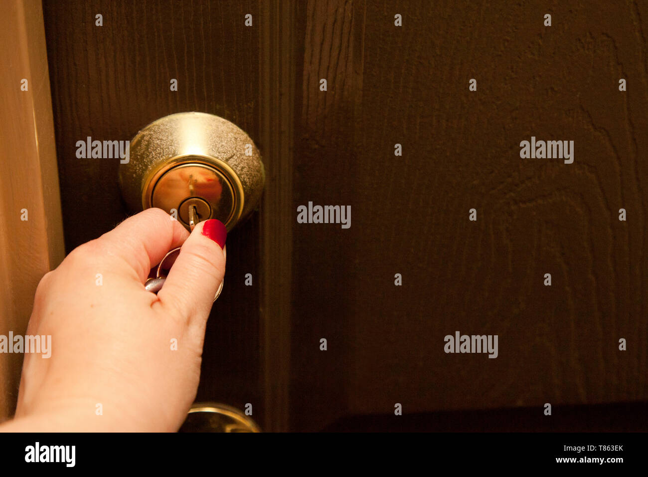 Hand fügt ein Schlüssel in das Schloss einer Tür Stockfoto