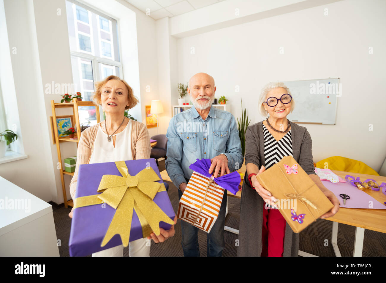 Freudige ältere Menschen zeigen sie ihre Geschenke Stockfoto