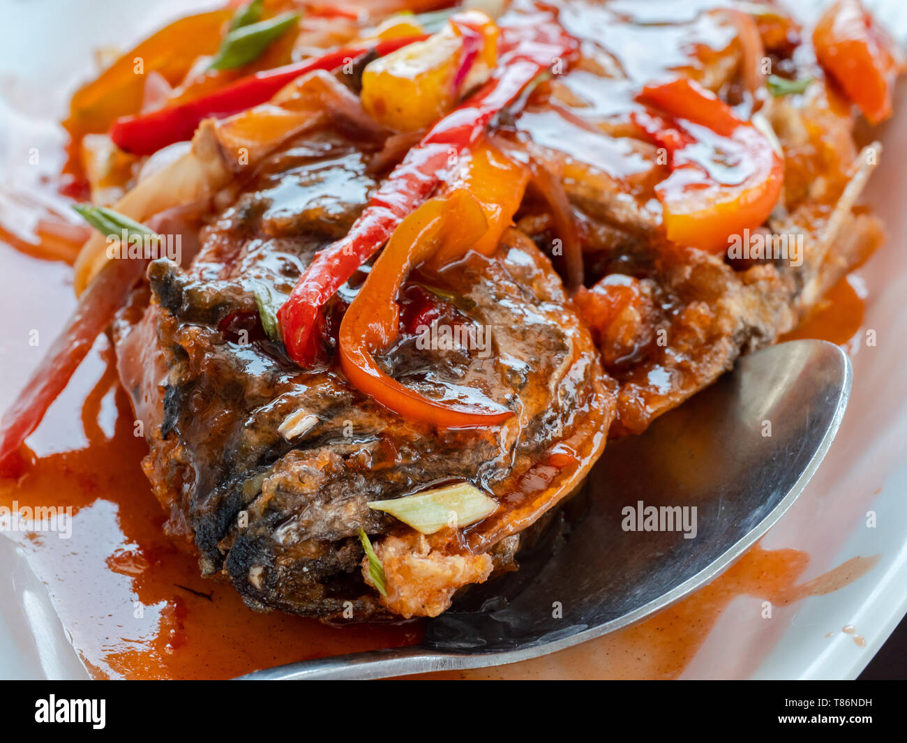 Frittierter Fisch mit süß-saurer Sauce, ein beliebtes Gericht in den meisten Ost- und Südostasien. Geringe Tiefenschärfe. Foto in den Philippin genommen Stockfoto