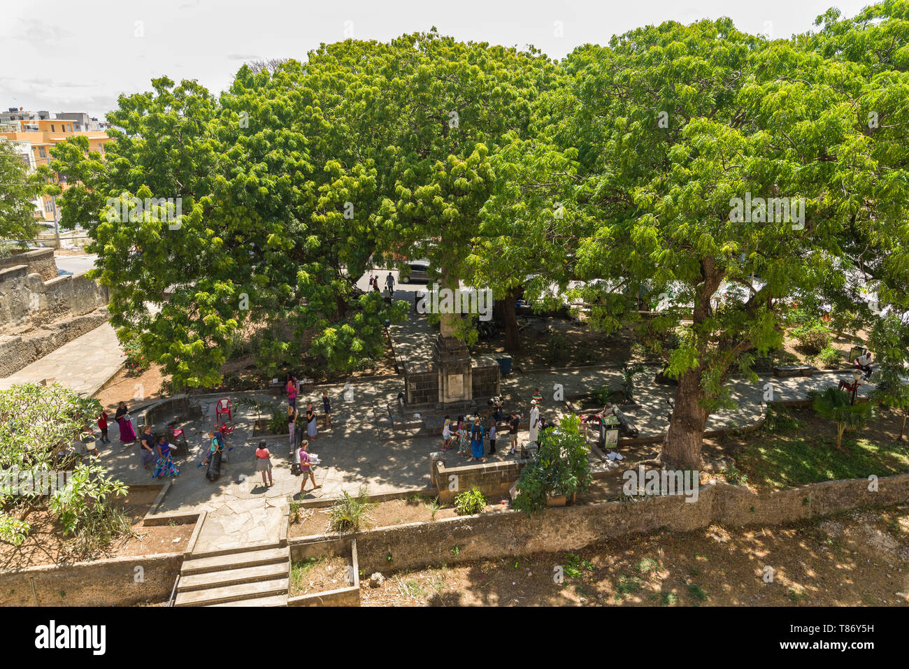 Fort Jesus Park mit Touristen und Einheimischen Wandern im Schatten der grossen Bäume, Mombasa, Kenia Stockfoto