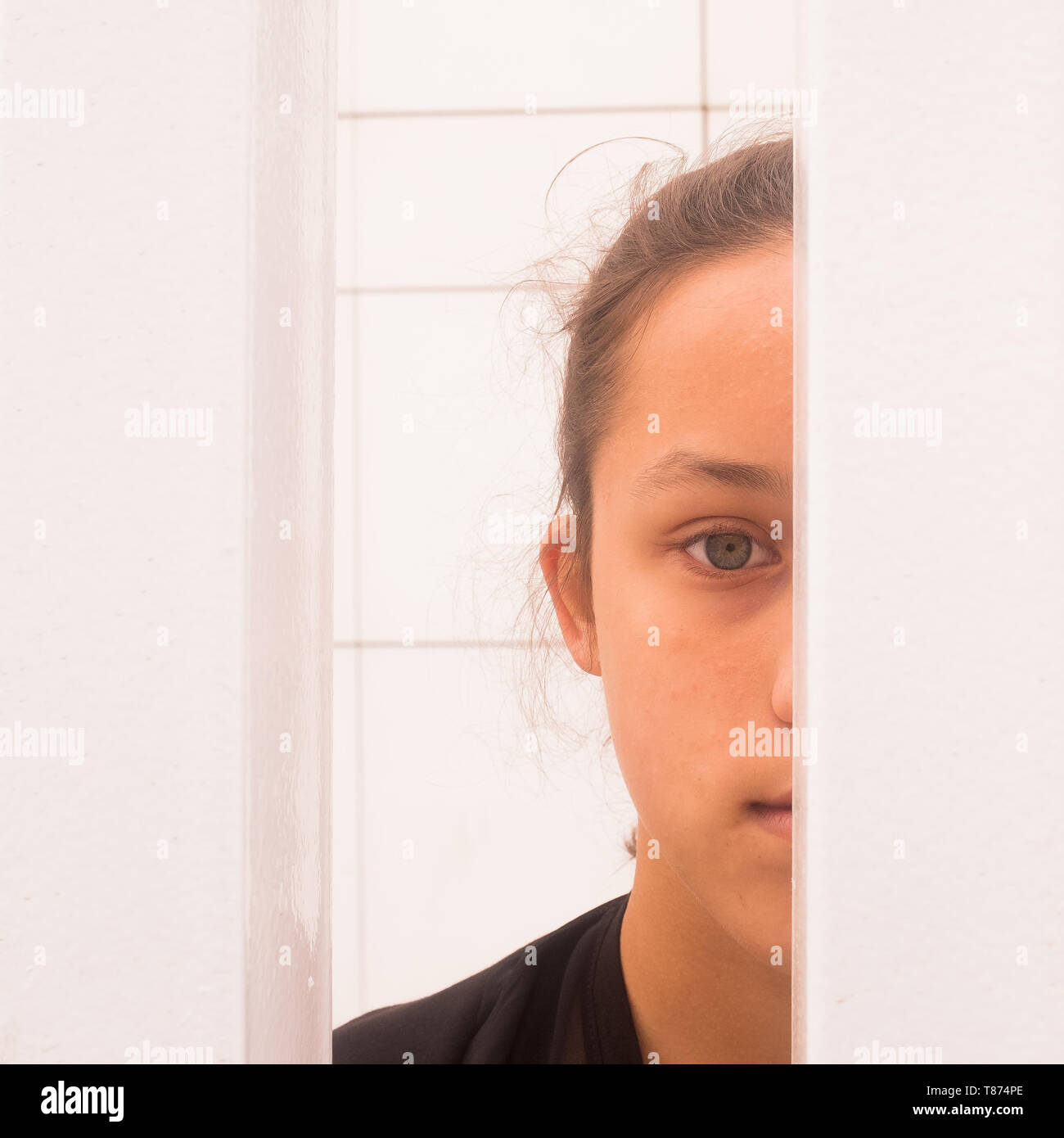 Schließen Sie die Hälfte Gesicht Porträt jugendlicher Mädchen schauen durch White Metal Bars, Selbstbewusstsein und Selbstwertgefühl Konzept, quadratischen Bild Stockfoto