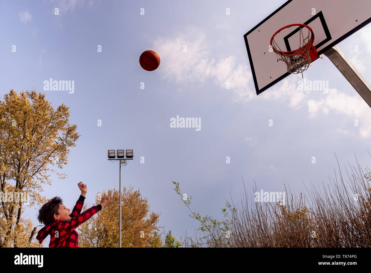 Körper Teil der dynamischen jungen Jungen mit erhobenen Armen schießen einen Basketball, horizontal Komposition, kopieren Raum Stockfoto