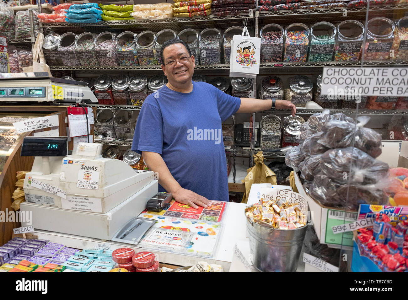 Ein langjähriger Mitarbeiter hinter der Theke auf der ikonischen WIRTSCHAFT CANDY auf Rivington Street auf der Lower East Side von Manhattan, New York City Stockfoto