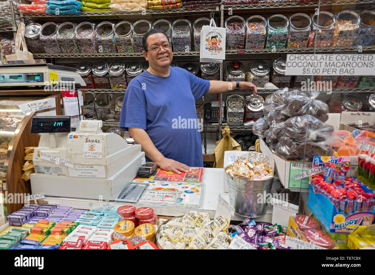 Ein langjähriger Mitarbeiter hinter der Theke auf der ikonischen WIRTSCHAFT CANDY auf Rivington Street auf der Lower East Side von Manhattan, New York City Stockfoto