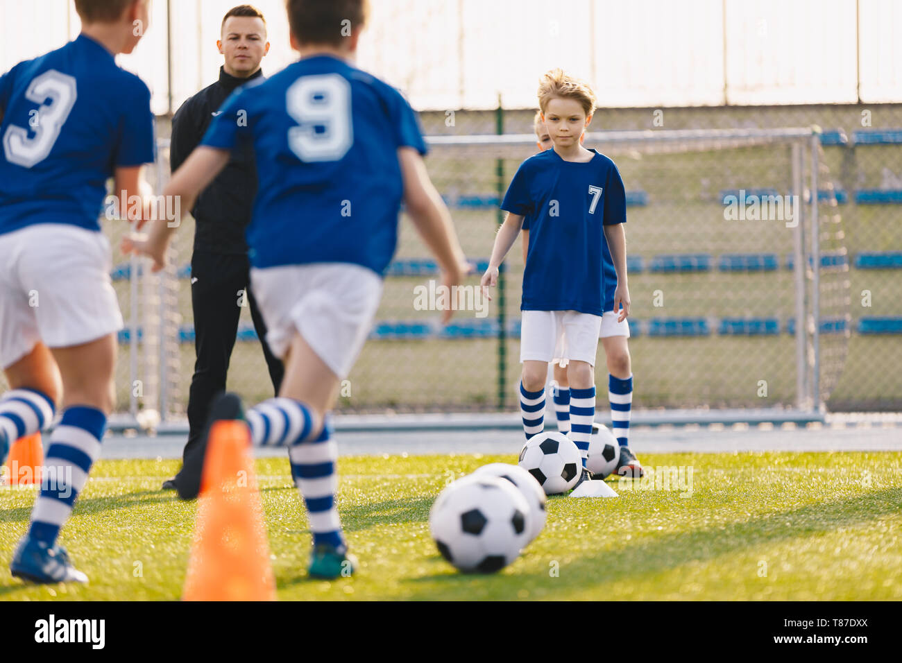 Kinder Training Fußball. Jungen laufen mit Ball auf Training Training. Happy Boys spielen Sport und Spaß im Freien Stockfoto