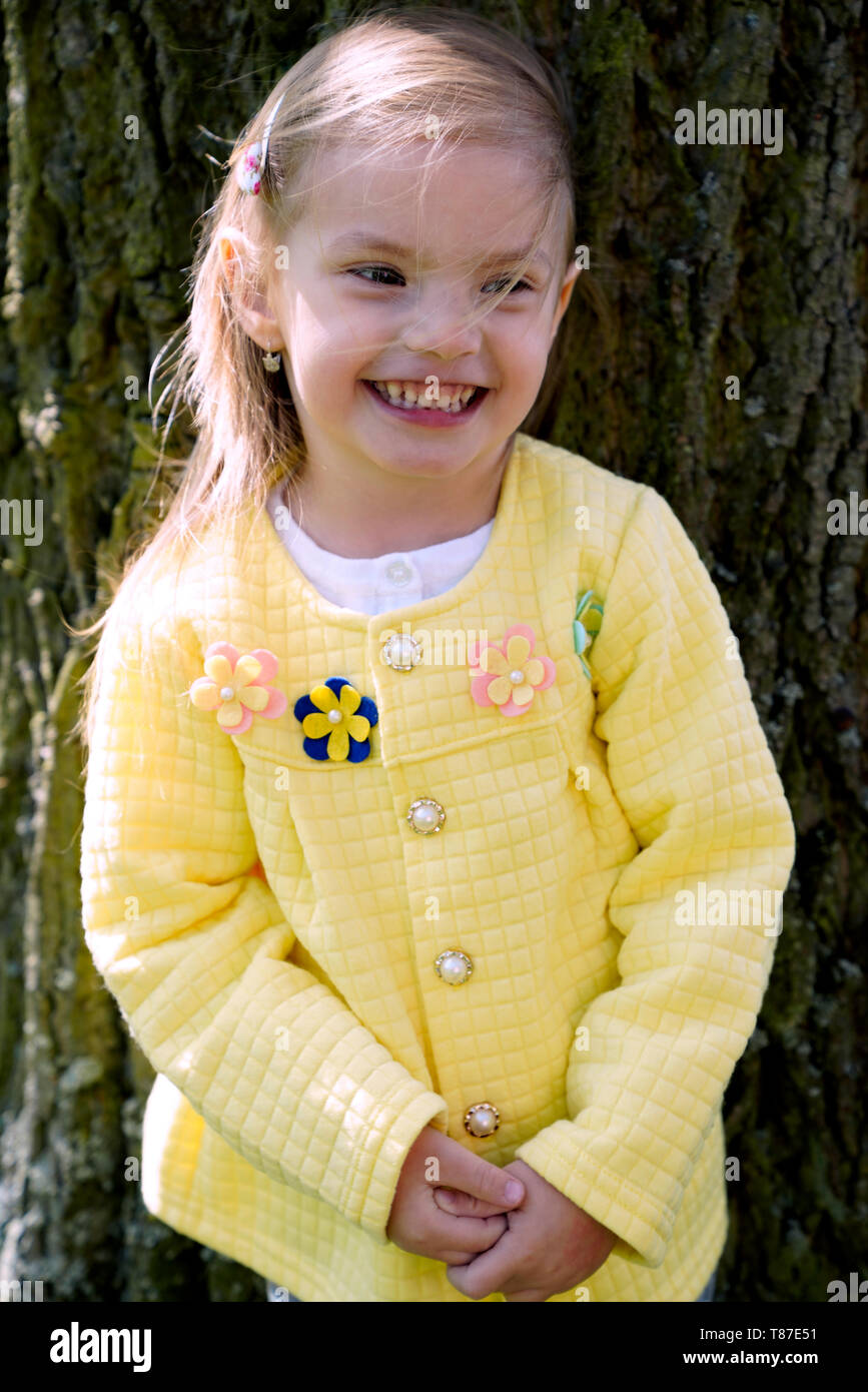 Portrait von kleinen Mädchen stehen und Stamm des alten Baumes Stockfoto