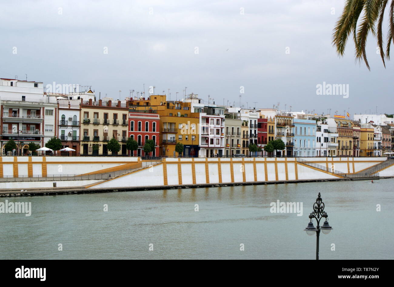 Blick über den Guadalquivir Fluss zu den bunten waterfront Gebäude von Triana, Sevilla, Spanien Stockfoto