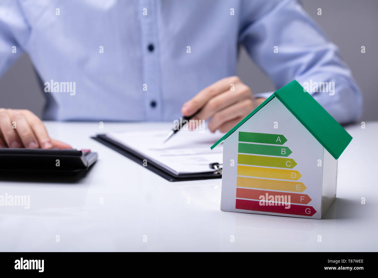 Haus mit Energie Wirkungsgrad Vor Geschäftsleute arbeiten im Büro, während mit Taschenrechner Stockfoto