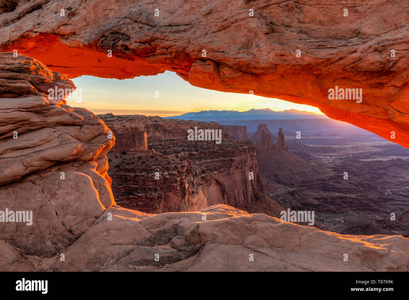 Die ersten Strahlen der warmen sunight hit Mesa Arch im Canyonlands National Park, Utah Stockfoto