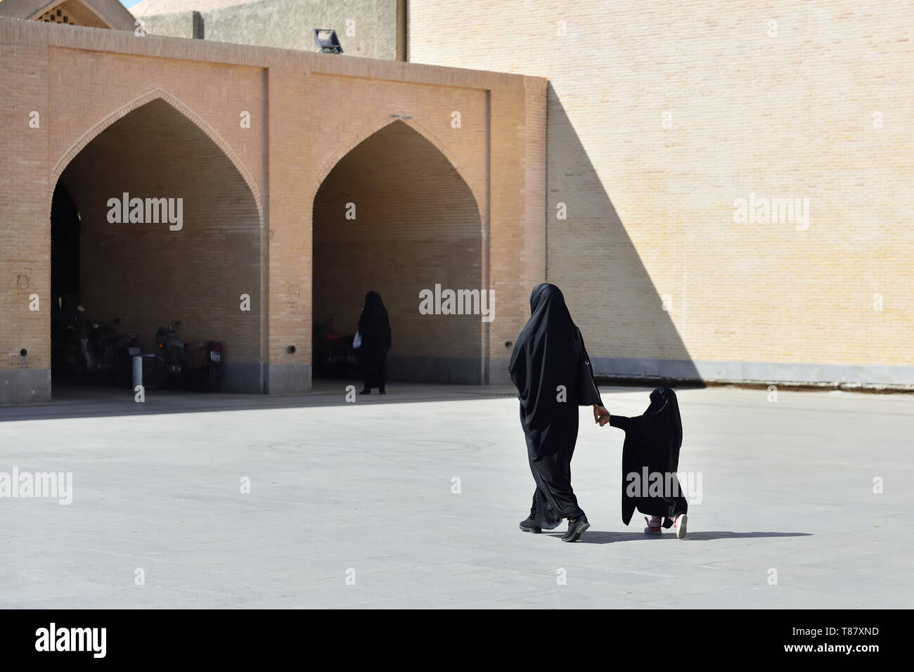 Muslimische Mutter mit der Tochter mit traditionellen Tschador entlang der Straßen in der Stadt Isfahan, Iran. Stockfoto