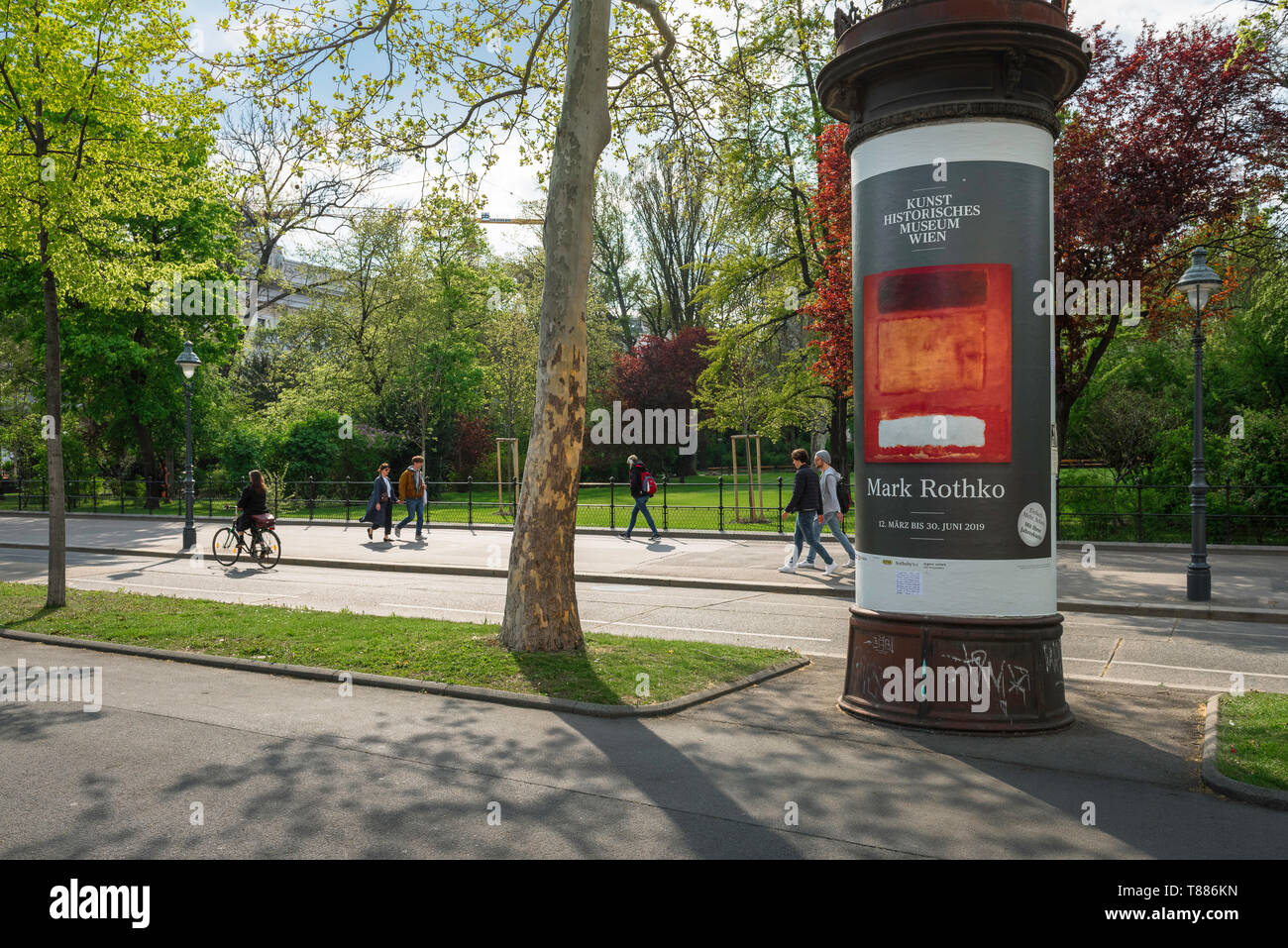 Wiener Innenstadt, Sommeransicht der Wiener, die entlang der Ringstraße mit einer typischen Werbsäule rechts, Wien, Österreich spazieren Stockfoto