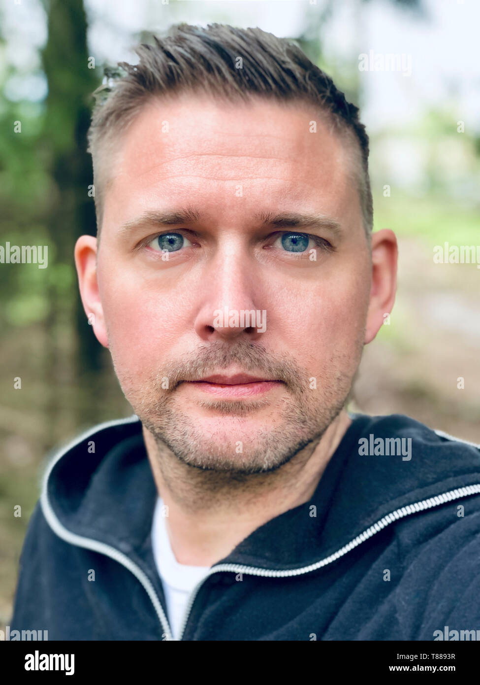 Schöne blaue Augen Mitte nach kaukasischen Close up up Gesicht portrait Natur mit Wald Hintergrund Stockfoto