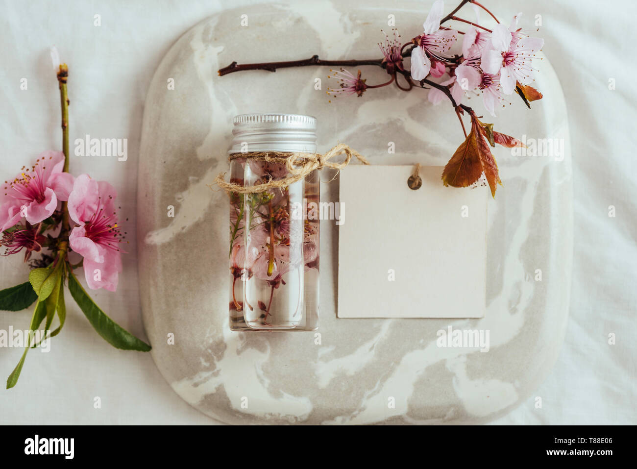 Ätherisches Öl, leere Tags und frischen Mandel Blumen, auf Marmor Platte Stockfoto