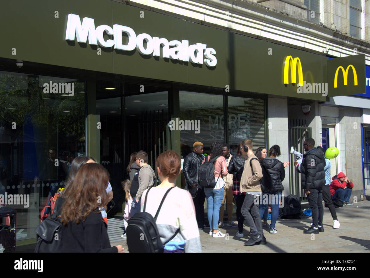 Außenansicht von McDonald's Shop in Piccadilly, Manchester, UK, als Mitglieder der Öffentlichkeit vorbei Stockfoto
