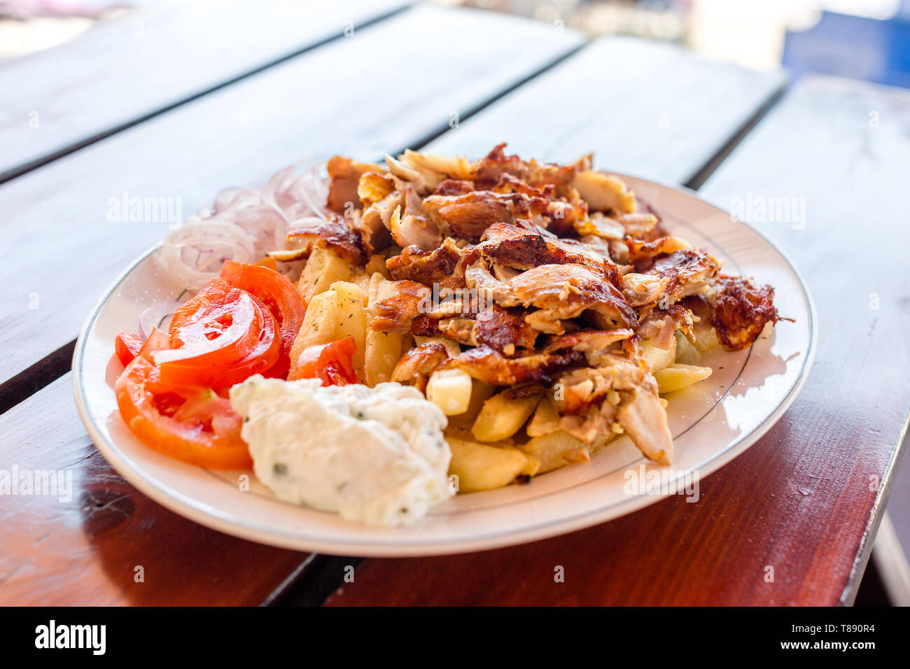 Leckere griechische Gyros mit Pommes frites, Gemüse und Tzatziki Soße auf weiße Platte Stockfoto