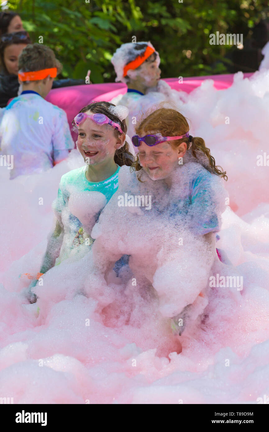 Dorchester, Dorset, Großbritannien. 12. Mai 2019. Weldmar des letzten jemals Bubble Rush erfolgt in Weymouth Mittel für die Nächstenliebe zu erhöhen. Die Teilnehmer haben Spaß, der in Schaum bedeckt, die durch Blasen in verschiedenen Farben. Credit: Carolyn Jenkins/Alamy leben Nachrichten Stockfoto