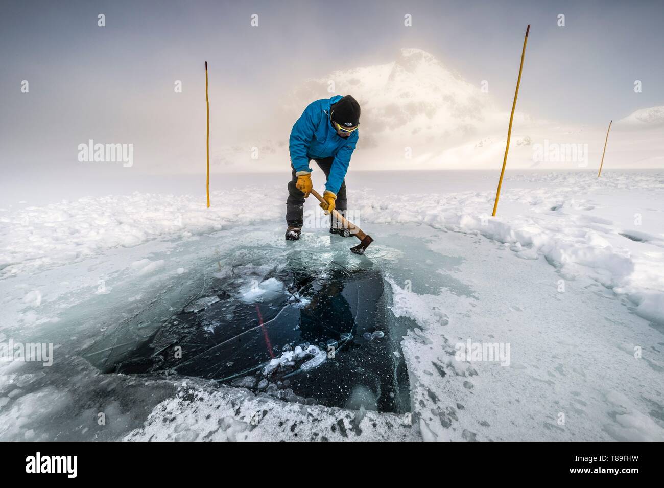 Frankreich, Isère (38), Belledonne, Chamrousse, Robert Seen, während ein Team von Tauchern bereitet unter dem Eis zu tauchen, der Direktor des Dive Xtreme Club bereitet die Oberlichter durch Brechen der kühlen Eis der Nacht Stockfoto