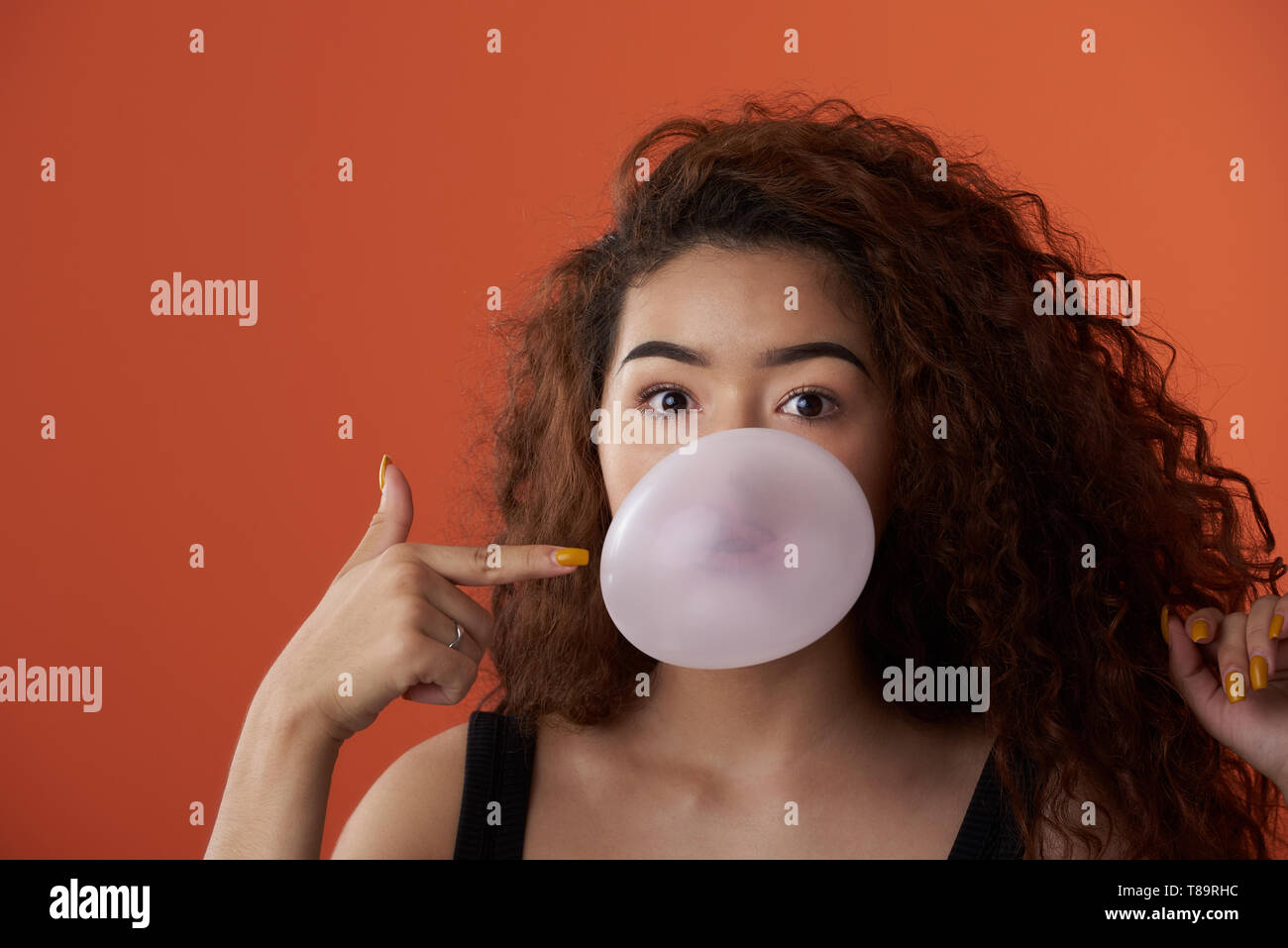 Lustige Portrait von Mädchen mit Bubble gum Ball im Studio Stockfoto