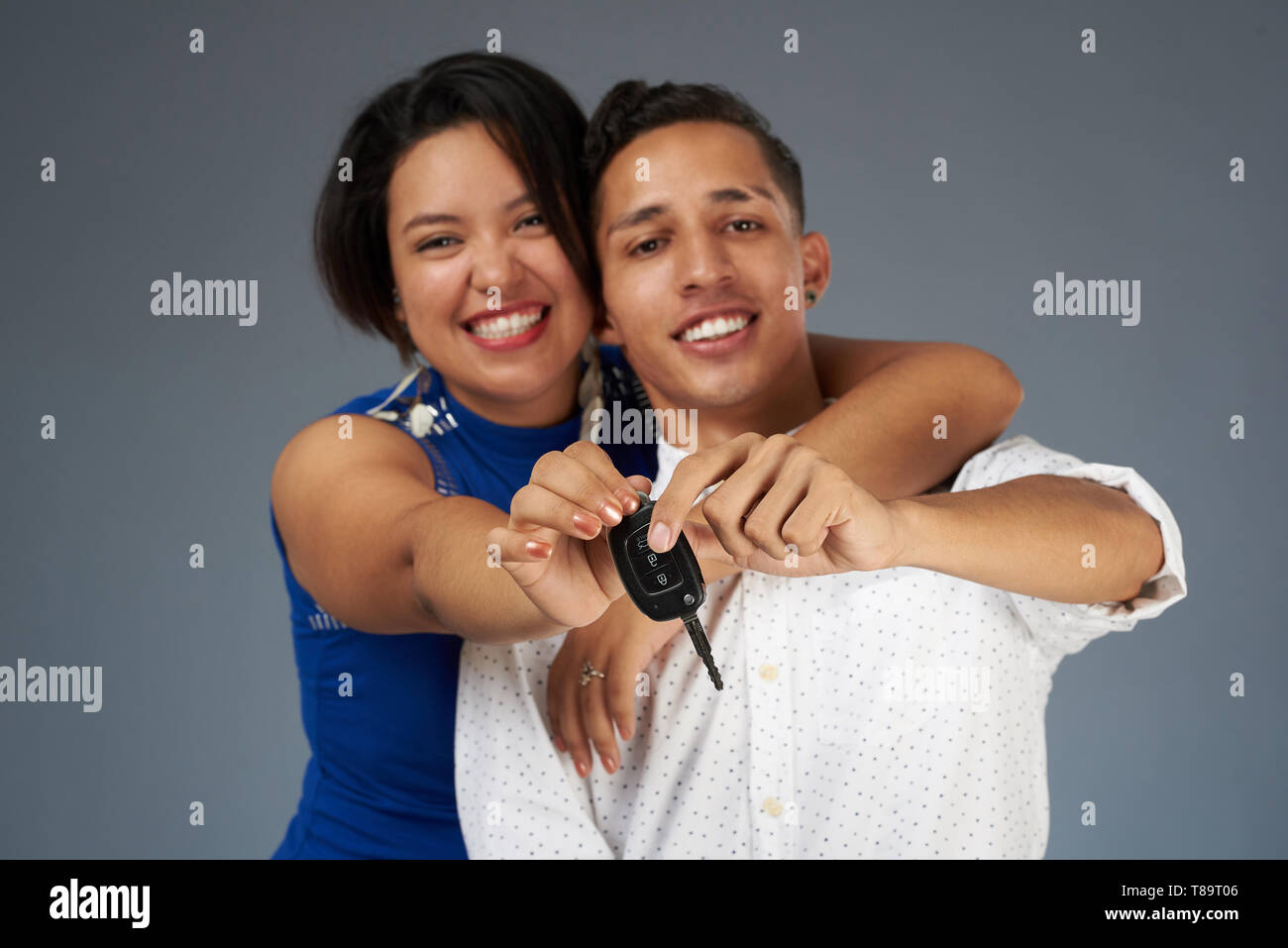 Auto-Taste gedrückt, lächelnden jungen Paar in Studio Hintergrund Stockfoto