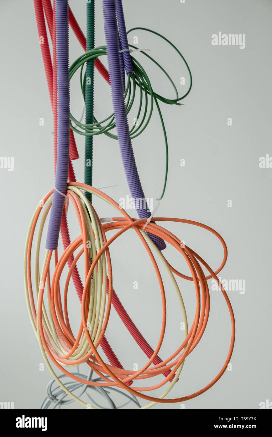 Eine Detailansicht der bunten elektrischen Kabel von der Decke hängen in den Spiralen und bündelt auf einer Baustelle Stockfoto
