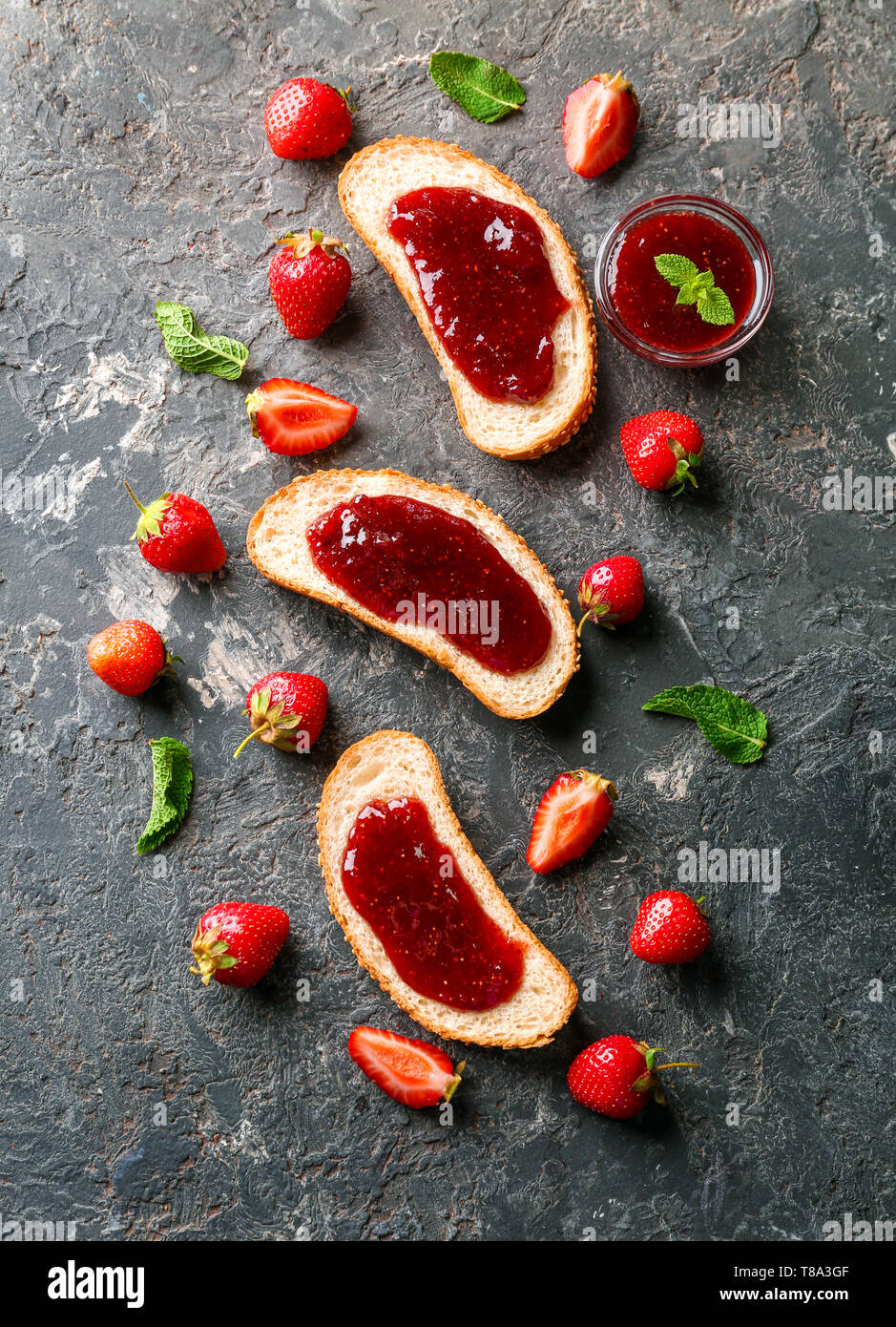Toast mit Erdbeermarmelade auf dunklem Hintergrund Stockfoto